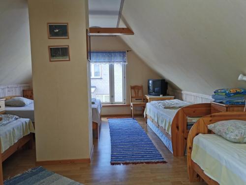 a attic room with two beds and a blue rug at Kaare Guesthouse in Viljandi