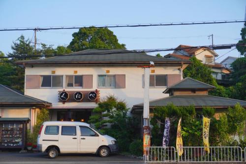 a white van parked in front of a building at Muji House Osaka Sannan Hotel 大阪泉南酒店良築 in Tannowa