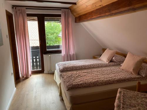 Hiša Planšar Bohinj accommodations في بوينج: غرفة نوم بسريرين ونافذة