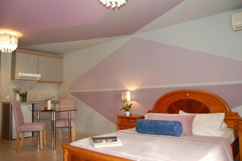 a bedroom with a bed and a table and a kitchen at Alkyoni Apartments & Studios in Poros