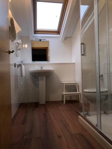 ein Bad mit einem Waschbecken, einem WC und einem Fenster in der Unterkunft Pension Casa da Nena in Muros