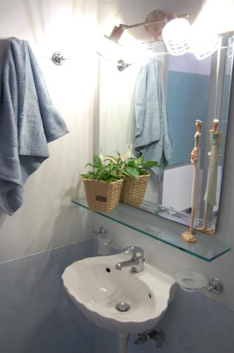 a bathroom with a sink and a mirror at Alkyoni Apartments & Studios in Poros