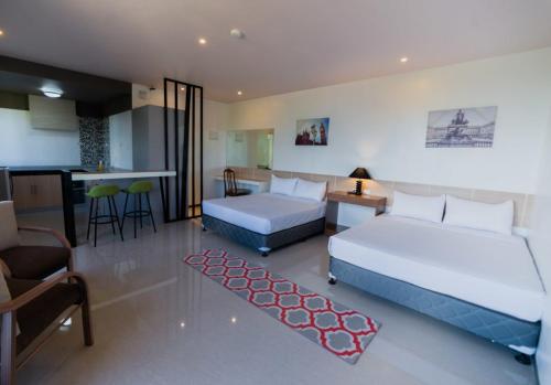 a hotel room with two beds and a kitchen and a kitchen at Soi Suites in Talibon