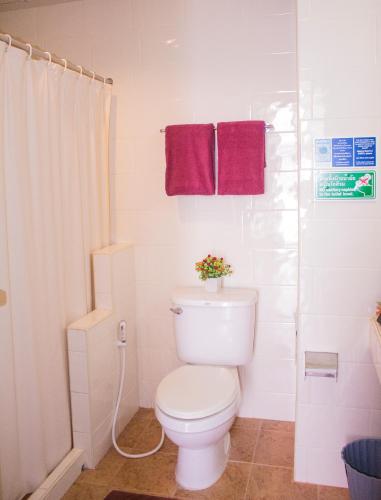 a bathroom with a toilet and two purple towels at People Place Boutique In Town Hotel - SHA Extra Plus in Chiang Mai