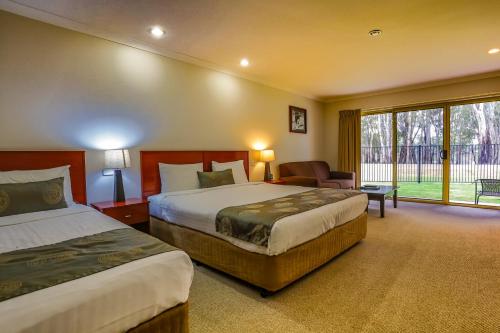 a hotel room with two beds and a window at Murray Waters Motor Inn & Apartments in Koondrook