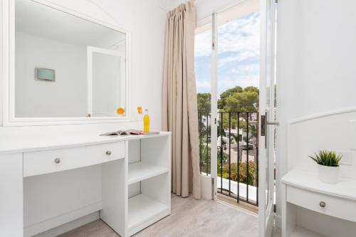 a white bathroom with a view of a balcony at Hostal Talamanca in Cala d´Or