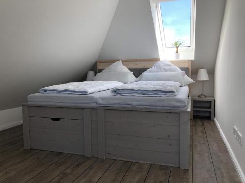 Cama en habitación con ventana en Ferienwohnung Böverdün en Sankt Peter-Ording