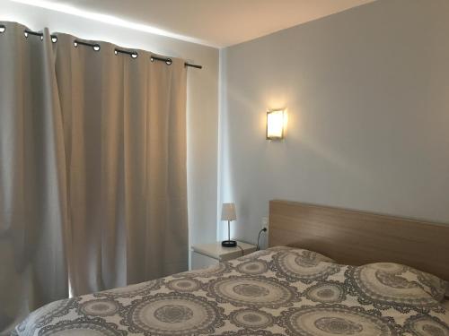 濱湖勒布爾歇的住宿－RESIDENCE DU PORT，一间卧室配有床和窗帘