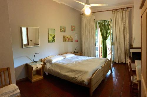 a bedroom with a large bed and a window at Agriturismo Orione in Marina di Campo