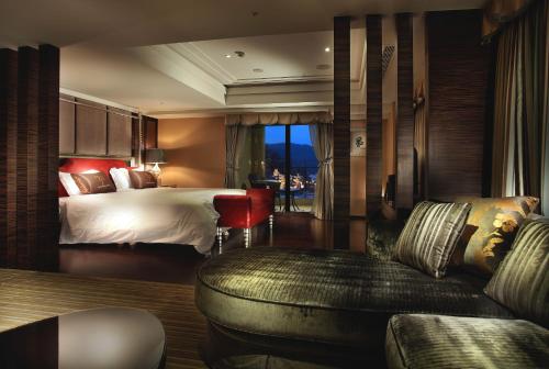 a hotel room with a bed and a couch at Sun Moon Lake Hotel in Yuchi