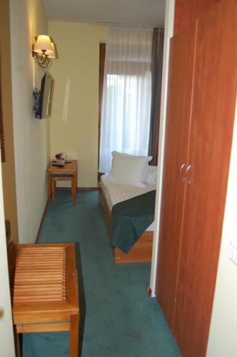 a hotel room with a bed and a window at Hotel Bucegi Portile Regatului in Paraul Rece
