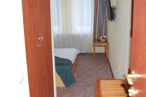 a small room with a bed and a window at Hotel Bucegi Portile Regatului in Paraul Rece