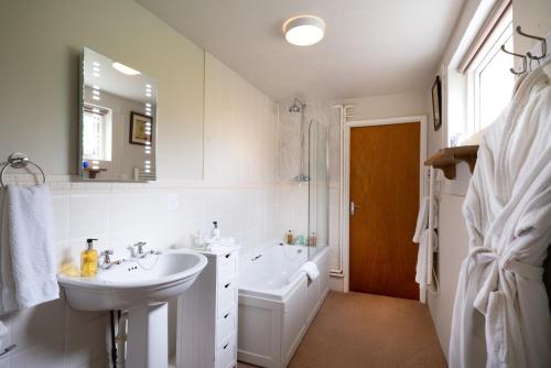 a bathroom with a sink and a toilet and a mirror at Ty Mawr Country Hotel & Restaurant in Carmarthen