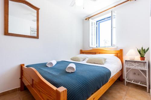 - une chambre avec un lit en bois et une couverture bleue dans l'établissement Casa Pedro Burgau, à Burgau