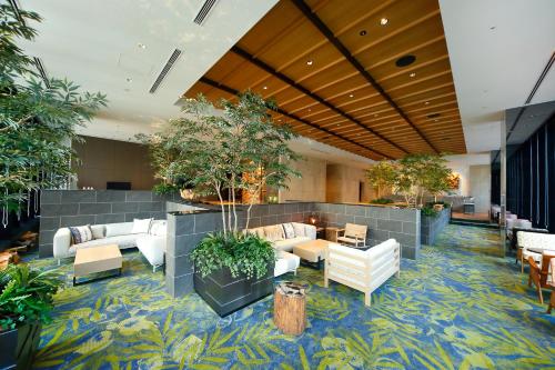 a lobby with couches and tables and plants at Miyako City Osaka Hommachi in Osaka