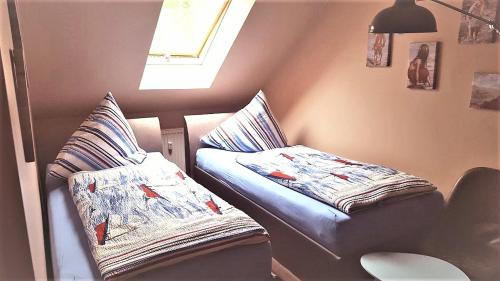 オストゼーバート・カールスハーゲンにあるFerienwohnung Jamieのベッド2台、枕、窓が備わる客室です。