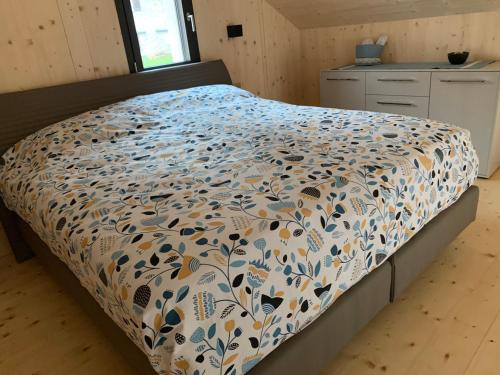 um quarto com uma cama com um edredão floral em House of retreat Strada Vegia de Brén 9 em Breno