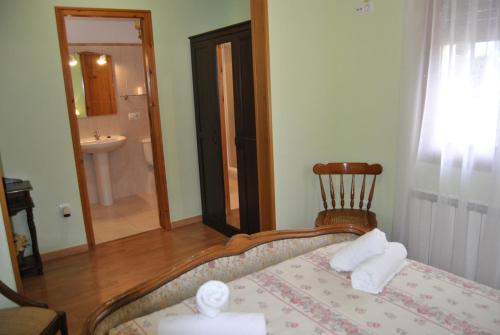 a bedroom with a bed and a bathroom with a sink at Cal Tonet in Castellserá