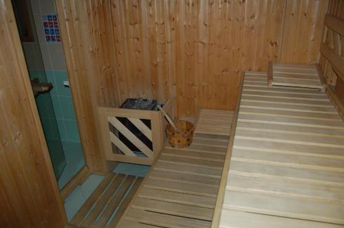 a sauna with wooden walls and a bucket in it at Hotel Bucegi Portile Regatului in Paraul Rece