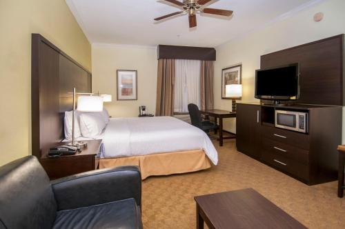 a hotel room with a bed and a flat screen tv at Holiday Inn Express Hotel & Suites Houston North Intercontinental by IHG in Houston