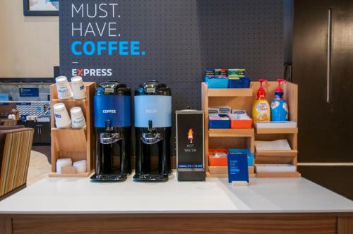 a counter with some bottles of coffee on it at Holiday Inn Express Hotel & Suites Houston North Intercontinental by IHG in Houston