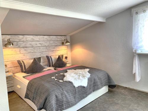 - une chambre avec un grand lit et une tête de lit en bois dans l'établissement Ferienwohnungen im Strandhus, à Kühlungsborn