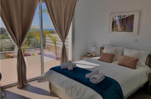 a bedroom with a large bed and a large window at Sophia's Seaview Luxury Villas in Paphos City