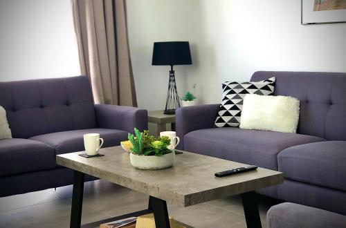 a living room with two purple couches and a coffee table at Sophia's Seaview Luxury Villas in Paphos City