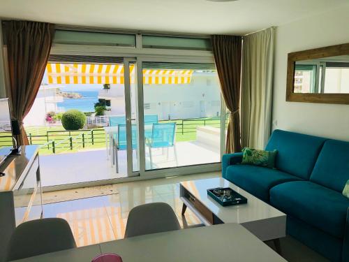 ein Wohnzimmer mit einem blauen Sofa und einem Balkon in der Unterkunft Almadrava Beach in Roses