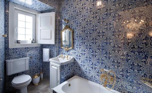 a blue and white bathroom with a toilet and a sink at Casa dell'Arte Club House in Lisbon