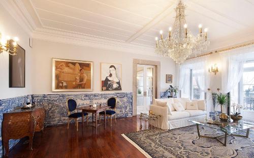 a living room with a white couch and a chandelier at Casa dell'Arte Club House in Lisbon