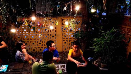 a group of people sitting in a bar at night at Trầm Homestay in Thôn An Hòa