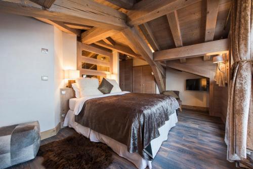 a bedroom with a large bed in a room with wooden ceilings at Chalet Opale in Tignes