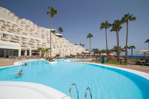 een groot zwembad in een resort met palmbomen bij Hotel Riu Calypso - Adults Only in Playa Jandia