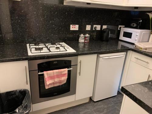 cocina con fogones horno superior junto a un microondas en Edinburgh Capital Apartments - 49 Elbe Street, en Edimburgo