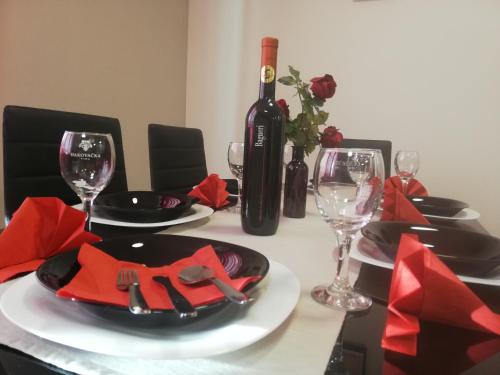 a dining table with a bottle of wine and glasses at Studio Apartment Lea in Čazma
