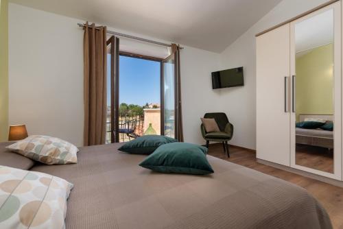 a bedroom with two beds and a large window at Villa Rotonda in Vrsar
