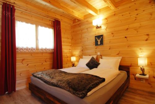 a bedroom with a bed in a log cabin at Le cocon du Catogne proche Martigny Verbier - Netflix - in Les Valettes
