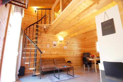 a living room with a couch and a spiral staircase at Le cocon du Catogne proche Martigny Verbier - Netflix - in Les Valettes