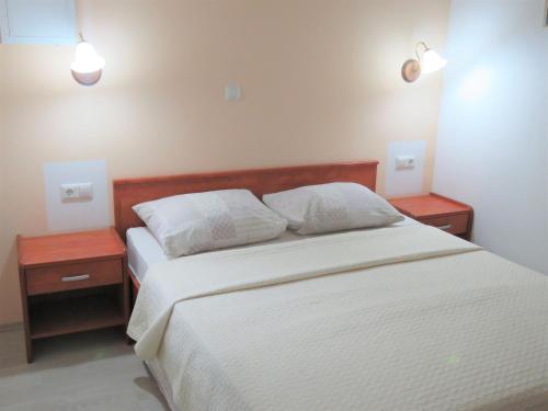 um quarto com uma cama branca com duas mesas de cabeceira em Apartmani Villa Delija Klek em Klek