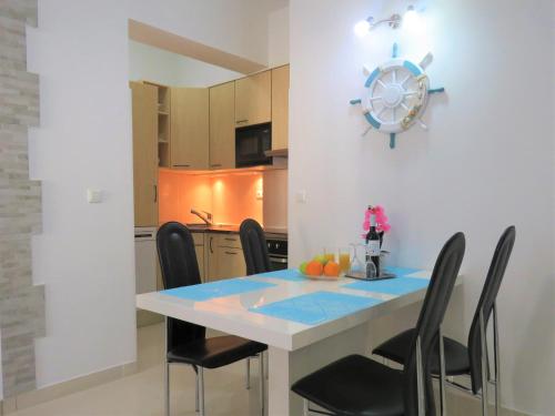 a kitchen with a dining table with black chairs at Apartmani Villa Delija Klek in Klek
