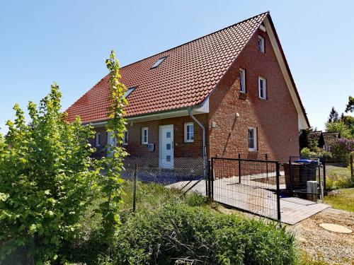 a brick house with a fence in front of it at Ferienhaus am Darß in Pruchten