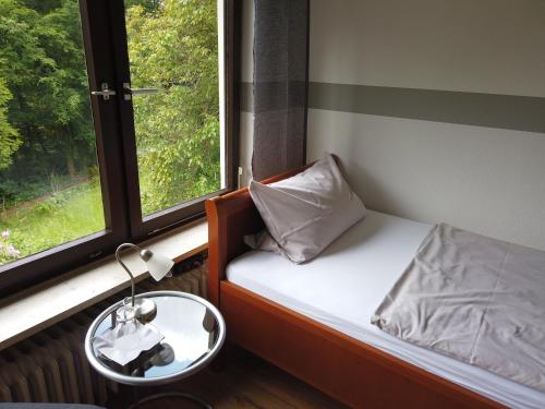 Cama pequeña en habitación con ventana en Hotel Waldterrasse, en Rengsdorf