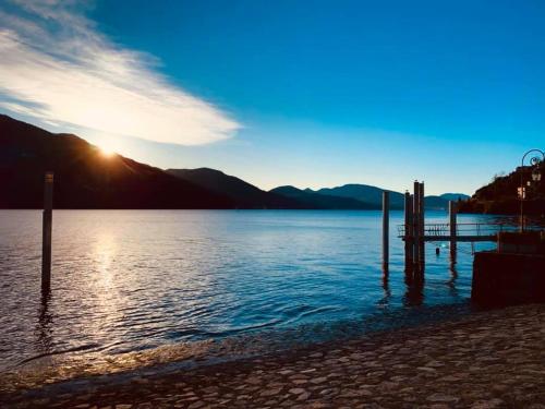 a view of a body of water with the sun setting at Hotel Del Fiume in Cannobio