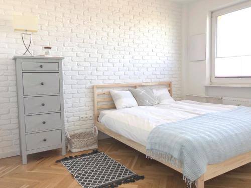 a bedroom with a bed and a white brick wall at Seaview Apartament z Balkonem i Widokiem na Morze in Sopot
