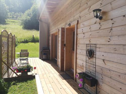 a wooden building with a patio with a table and chairs at Le cocon du Catogne proche Martigny Verbier - Netflix - in Les Valettes
