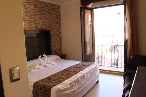 a bedroom with a bed and a large window at Hotel San Diego in Guanajuato