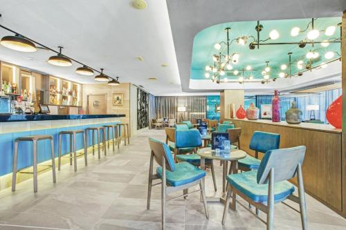 a restaurant with blue chairs and a bar at Hotel Riu Festival in Playa de Palma