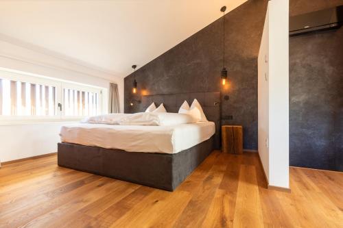 a bedroom with a large bed and wooden floors at Innerbachlerhof - Gantkofel in Postal