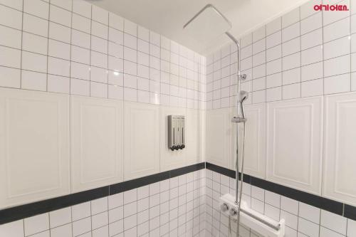 a bathroom with a shower with white tiled walls at Hotel Yeogijoa in Gwangju